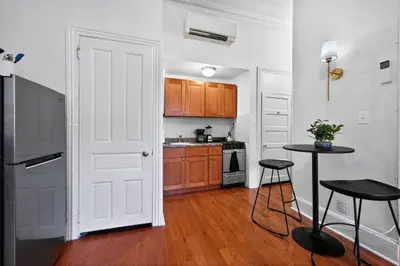a kitchen with a white door and a table with stools at Sunny 1BR in Center City with King Sized Memory Foam Sofa Bed in Philadelphia