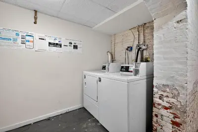 a kitchen with white appliances and a brick wall at Sunny 1BR in Center City with King Sized Memory Foam Sofa Bed in Philadelphia