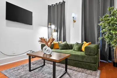 a living room with a green couch and a table at Sunny 1BR in Center City with King Sized Memory Foam Sofa Bed in Philadelphia