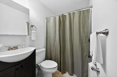 a bathroom with a sink toilet and a shower curtain at Sunny 1BR in Center City with King Sized Memory Foam Sofa Bed in Philadelphia