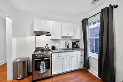 a kitchen with white cabinets and a stove at Large Studio in Center City that Sleeps 4 with Fast Wifi in Philadelphia