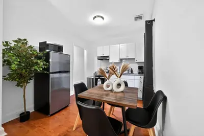 a kitchen with a table with chairs and a refrigerator at Large Studio in Center City that Sleeps 4 with Fast Wifi in Philadelphia