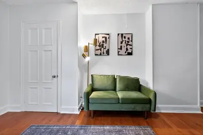 a green couch in a white room with a door at Large Studio in Center City that Sleeps 4 with Fast Wifi in Philadelphia