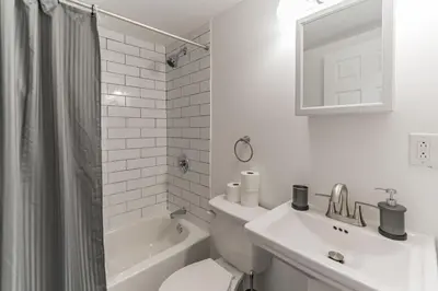 a white bathroom with a toilet and a sink at 5BR - Sleeps 14 - Street Parking - 10 min to DT in Philadelphia