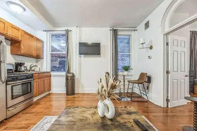 a kitchen with white walls and wooden cabinets and a table at Charming 1BR in Center City that Sleeps 4 with Fast WiFi in Philadelphia