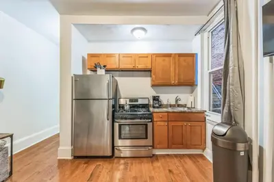 a kitchen with stainless steel appliances and wooden cabinets at Charming 1BR in Center City that Sleeps 4 with Fast WiFi in Philadelphia