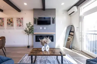 a living room with a fireplace and a table at 1 BR Across from Fairmount Park -10 mins to DT (D) in Philadelphia