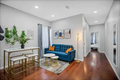 a living room with a blue couch and a table at Charming Center City 2BR - Sleeps 8 people in Philadelphia