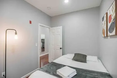 a white bedroom with a bed and a door at Charming Center City 2BR - Sleeps 8 people in Philadelphia