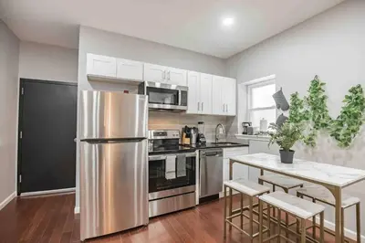 a kitchen with a stainless steel refrigerator and a table at Charming Center City 2BR - Sleeps 8 people in Philadelphia