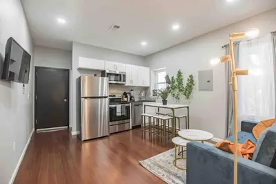 a living room with a blue couch and a kitchen at Charming Center City 2BR - Sleeps 8 people in Philadelphia