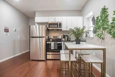 a kitchen with a table and a stainless steel refrigerator at Charming Center City 2BR - Sleeps 8 people in Philadelphia
