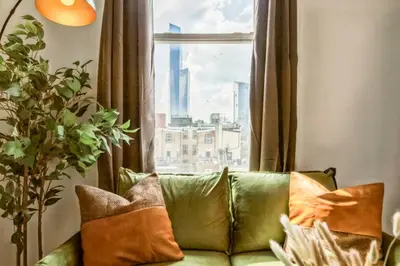 a green couch sitting in front of a window at New Studio in Center City that Sleeps 4 with Fast Wifi in Philadelphia