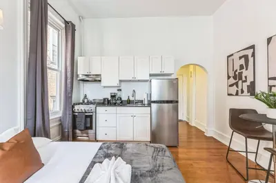 a kitchen with white cabinets and a stainless steel refrigerator at New Studio in Center City that Sleeps 4 with Fast Wifi in Philadelphia