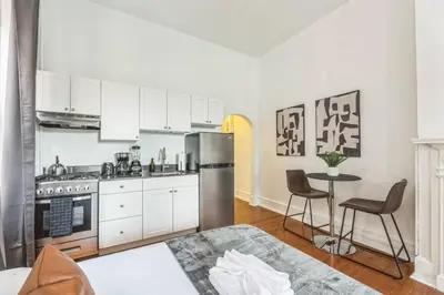 a kitchen with a stainless steel refrigerator and a table at New Studio in Center City that Sleeps 4 with Fast Wifi in Philadelphia