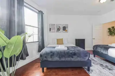 a bedroom with a bed and a large window at 1BR Across Convention Center in Philadelphia