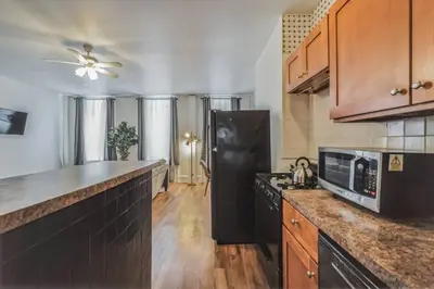 a kitchen with a black refrigerator and wooden cabinets at Large Historical 1BR Center City that Sleeps 4 in Philadelphia