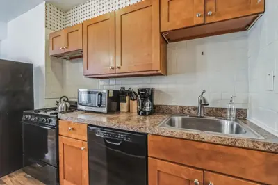 a kitchen with wooden cabinets and a sink at Large Historical 1BR Center City that Sleeps 4 in Philadelphia