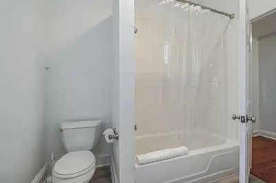a white bathroom with a toilet and a shower at Huge and Sunny 1BR in Center City in Philadelphia