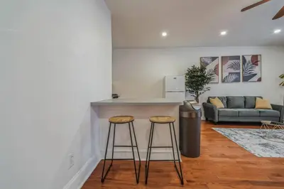 a kitchen with two bar stools and a couch at Huge and Sunny 1BR in Center City in Philadelphia