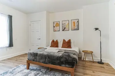 a white bedroom with a bed and a table at Large and Cozy Center City 1BR in Philadelphia