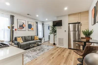 a living room with a couch and a kitchen at Large and Cozy Center City 1BR in Philadelphia