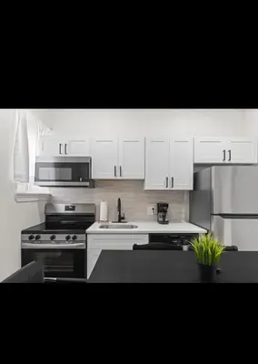 a kitchen with white cabinets and a stove at Modern 2 bedroom 1 bath unit 2 Near Airport, Xfinity Arena and Eagles Stadium in Philadelphia