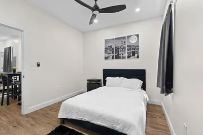 a white bedroom with a bed and a ceiling fan at Modern 2 bedroom 1 bath unit 2 Near Airport, Xfinity Arena and Eagles Stadium in Philadelphia