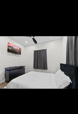 a bedroom with a white bed and a painting on the wall at Modern 2 bedroom 1 bath unit 2 Near Airport, Xfinity Arena and Eagles Stadium in Philadelphia