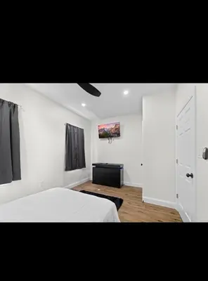 a bedroom with a white bed and a window at Modern 2 bedroom 1 bath unit 2 Near Airport, Xfinity Arena and Eagles Stadium in Philadelphia
