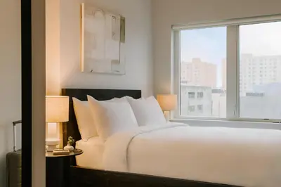 a bedroom with a large white bed and a window at Sosuite at The Ovation - Ave of The Arts in Philadelphia