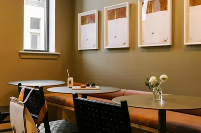 a restaurant with two tables and chairs and windows at Sosuite at The Ovation - Ave of The Arts in Philadelphia