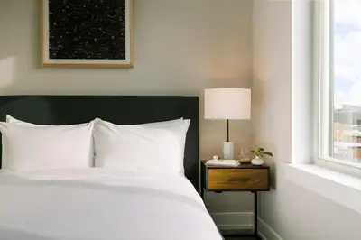 a bedroom with a white bed and a window at Sosuite at The Ovation - Ave of The Arts in Philadelphia