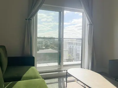 a room with a large window with a view of a city at Sosuite at The Ovation - Ave of The Arts in Philadelphia