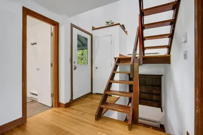 a wooden staircase in a room with a door at House Under The Cliff in New Paltz