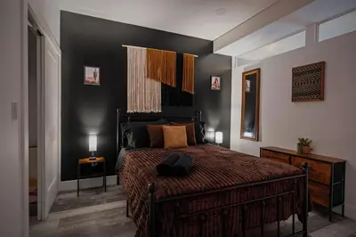 a bedroom with a bed and a black wall at Cozy Desert Den 10 Min Downtown& 6 Min Brewerytown in Philadelphia