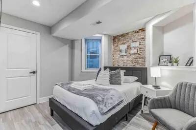 a bedroom with a bed and a brick wall at Large Bi-Level 3BR w Patio - 10 min to DT in Philadelphia