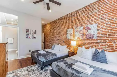 a bedroom with two beds and a brick wall at Large Bi-Level 3BR w Patio - 10 min to DT in Philadelphia