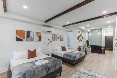 a hotel room with two beds and a television at Large Studio w 2 Beds and Balcony (C) in Philadelphia