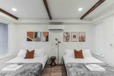 two beds in a room with white walls and windows at Large Studio w 2 Beds and Balcony (C) in Philadelphia