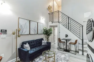 a living room with a blue couch and a table at Large Bi-Level 2BR Loft in Old City that Sleeps 8 in Philadelphia