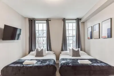 two beds in a room with windows at Large Bi-Level 2BR Loft in Old City that Sleeps 8 in Philadelphia