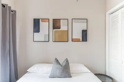 a bedroom with four framed pictures on the wall at Large Bi-Level 2BR Loft in Old City that Sleeps 8 in Philadelphia