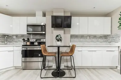 a kitchen with white cabinets and a table and chairs at Large 2BR in Old City that Sleeps 8 in Philadelphia