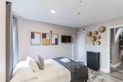 a bedroom with a large bed and a television at Large 2BR in Old City that Sleeps 8 in Philadelphia