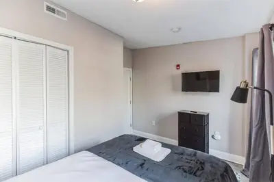 a bedroom with a bed and a tv on the wall at Large 2BR in Old City that Sleeps 8 in Philadelphia
