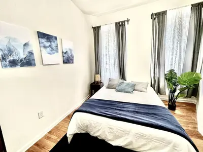 a bedroom with a bed in a room with windows at Incredible Location - Large Center City 2 BR in Philadelphia