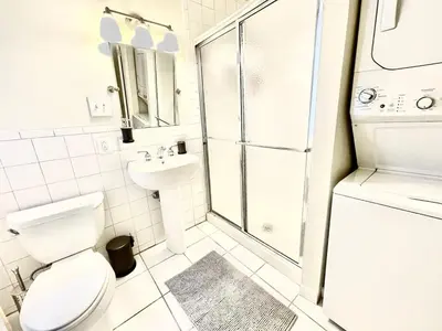 a white bathroom with a toilet and a shower at Incredible Location - Large Center City 2 BR in Philadelphia