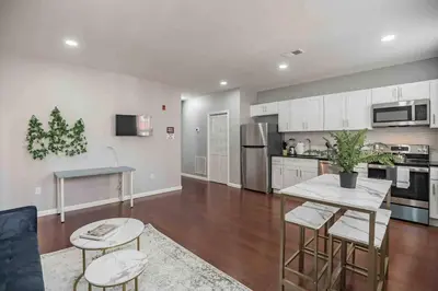 a kitchen with white cabinets and a table and chairs at Large and Sunny 1BR - Center City - Sleeps 4 in Philadelphia