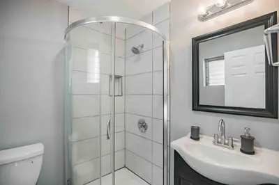 a white bathroom with a shower and a sink at Large and Sunny 1BR - Center City - Sleeps 4 in Philadelphia